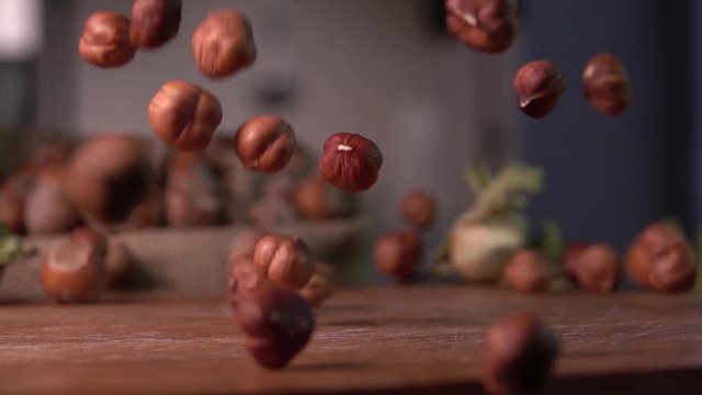 hazelnuts falling on cutting wood board ,slow motion 240 fps, shot on sony rx 10