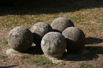 Old gray cannonballs lie on the ground