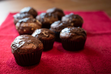 Chocolate muffins on red cloth.