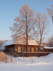 Sunset. Old traditional Russian wooden house. Winter, Russia, Ural, Perm Region