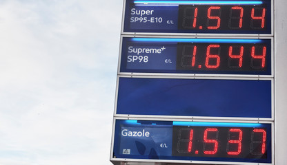 Blue board with price of gasoline petrol, written in red. Close up