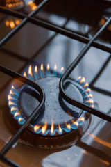 Gas stove with burning orange and blue fire on it