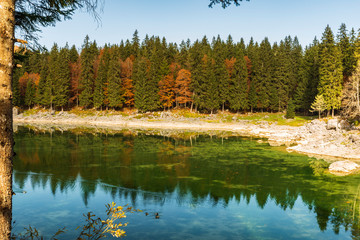 Upper Lake of Fusine, Tarvisio. Autumnal fire reflections. At the foot of the Mangart