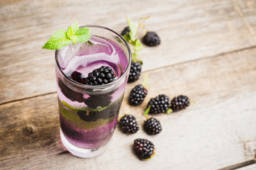 Blackberry mojito cocktail on the wooden background. Selective focus. Shallow depth of field.