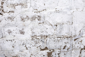 brick plastered wall with whitewash with potholes, cracks and stains, shot on a cloudy autumn day