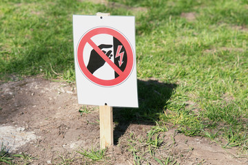 High voltage warning sign on a green lawn. danger Keep out. Danger sign of high voltage electricity