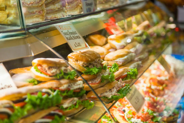Varied sandwiches and pizza on the counter of a street cafe