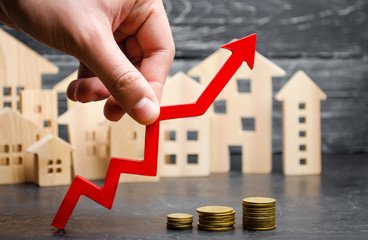 Wooden houses stand in a row from small to large with a red arrow up. concept of high demand for...