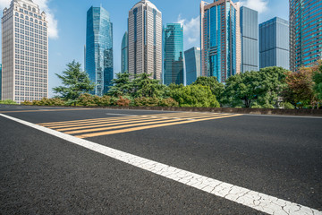Fototapeta na wymiar Empty asphalt road along modern commercial buildings in China's cities