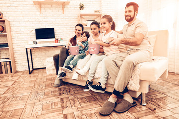 Naklejka premium Lovely Cheerful Family Watching Movie at Home