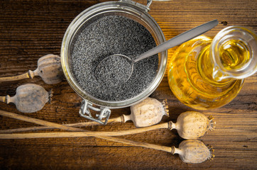 poppy seeds and oil on an old wooden table