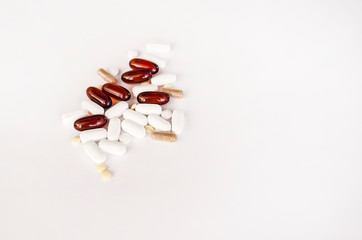 Multicolored pills, capsules and vitamins isolated on white background, top view. Healthcare and supplements. Antioxidants, fish oil, calcium, ginkgo biloba, biotin, flax oil. Selective focus