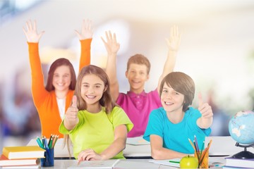 Friendly school children at school studying subject, gesturing