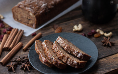 Homemade banana bread with anis star and cinnamon on a dark wooden background