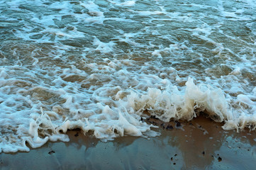 The waves beating against the stone. The pebbles are washed by waves on the sea.