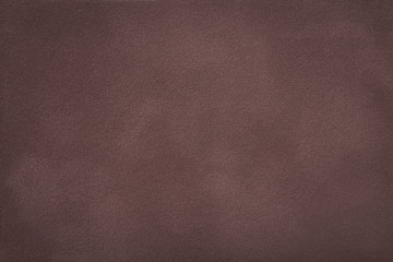 Dark brown matt suede fabric closeup. Velvet texture.