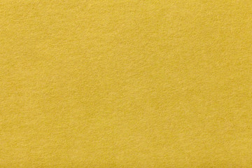 Light yellow matt suede fabric closeup. Velvet texture of felt.