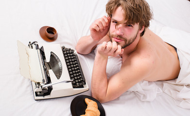 Lack of inspiration or idea. Creativity crisis. Man writer lay bed bedclothes working book. Writer...