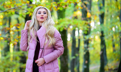 Girl fashionable blonde walk in autumn park. Autumn hair care concept. Autumn hair care is important so as to avoid dry frizzy hair. Cold blonde concept. How to repair bleached hair fast and safely
