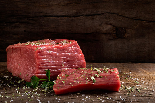 Raw beef meat with herbs on wood