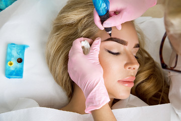 Beautiful woman with smooth, young skin, sitting in a beautician. A beautician performs modeling...