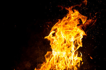 Fototapeta premium Burning woods with firesparks, flame and smoke. Strange weird odd elemental fiery figures on black background. Coal and ash. Abstract shapes at night. Bonfire outdoor on nature. Strenght of element.