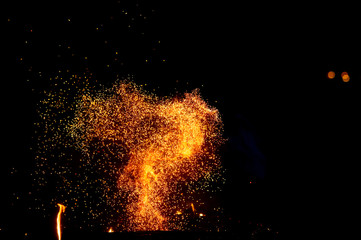 Burning woods with firesparks, flame and smoke. Strange weird odd elemental fiery figures on black background. Coal and ash. Abstract shapes at night. Bonfire outdoor on nature. Strenght of element.