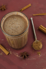 top view hot sweet spicy  homemade cocoa ,cinnamon sticks , anise stars and dry cocoa powder spoon  on a brown shabby wooden table