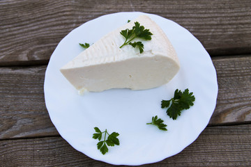 Bryndza in a plate on wooden table. Top view