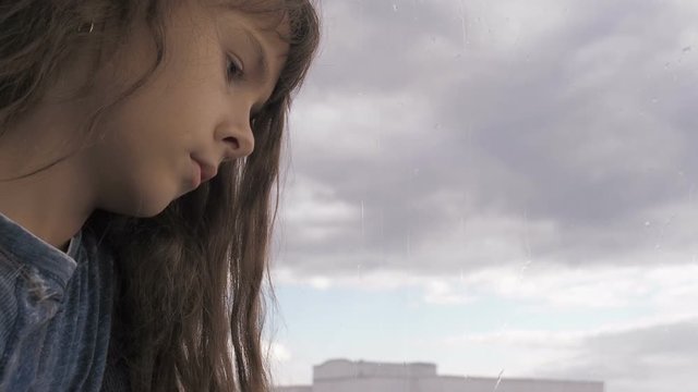 A Depressed Child Looks Out The Window.