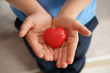 Little boy holding decorative heart, closeup