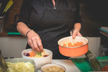 hand of a cook preparing a colorful healthy dish