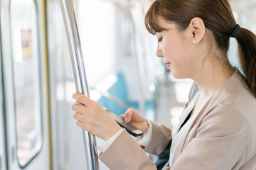 女性・通勤・スマートフォン © naka