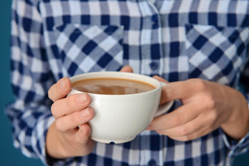 Woman holding cup of aromatic coffee, closeup