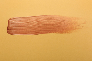 Stroke of gold paint on color background