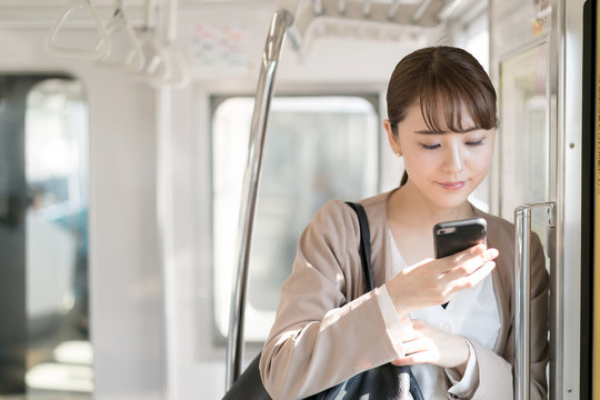 女性・通勤・スマートフォン