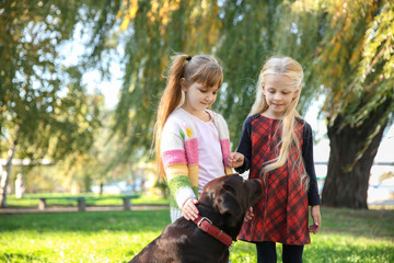 Cute little girls with dog in autumn park