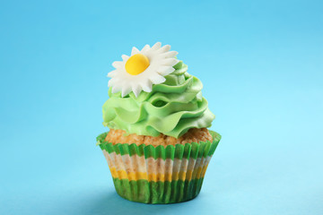 Tasty cupcake on color background