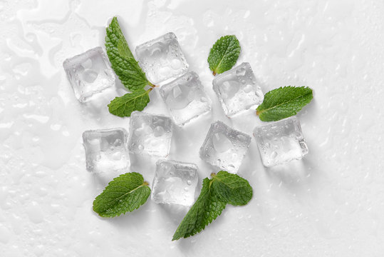 Ice cubes and mint leaves on white background