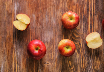 Cut and whole juicy apples on wooden table