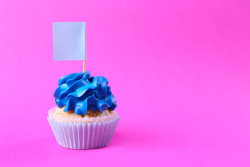 Tasty cupcake with tag on color background