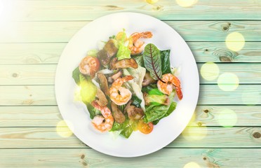 Spaghetti with shrimps, tomatoes and chopped parsley on wooden