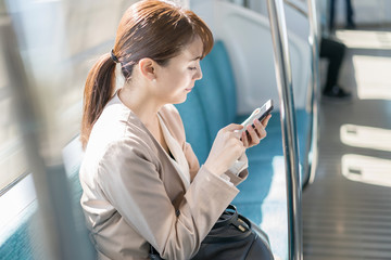 女性・通勤・スマートフォン