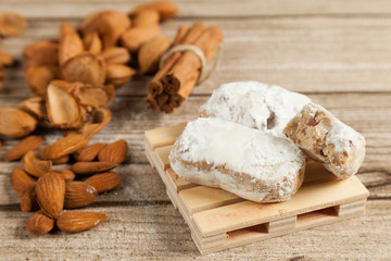 typical Spanish almond  polvorón, almond  and cinnamon on wood table
