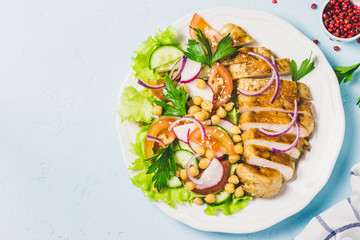 Grilled chicken with fresh vegetables olive oil dressing. Selective focus, Space for text.