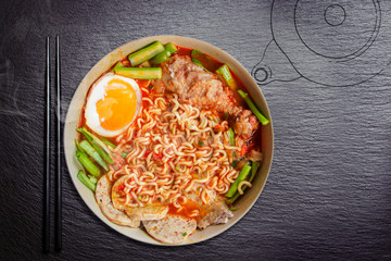 Hot and Spicy noodle in bowl and ingredients on wood background, Korea noodles with boil eggs in bowl with chopsticks and Chalk hand drawing Kettle, copy space and top view