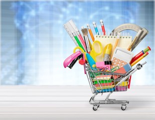 Colorful school supplies in shopping cart
