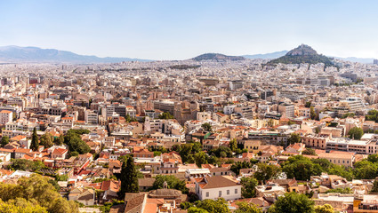 Fototapeta na wymiar Athens city panorama with small greek buildings, churches and hills on horizon.