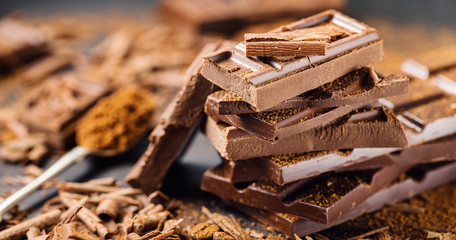 Pile of broken dark chocolate on table