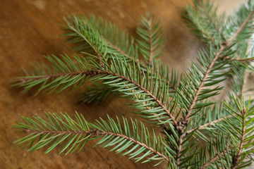 Obraz premium Needle like leaves of spruce branch on wooden table